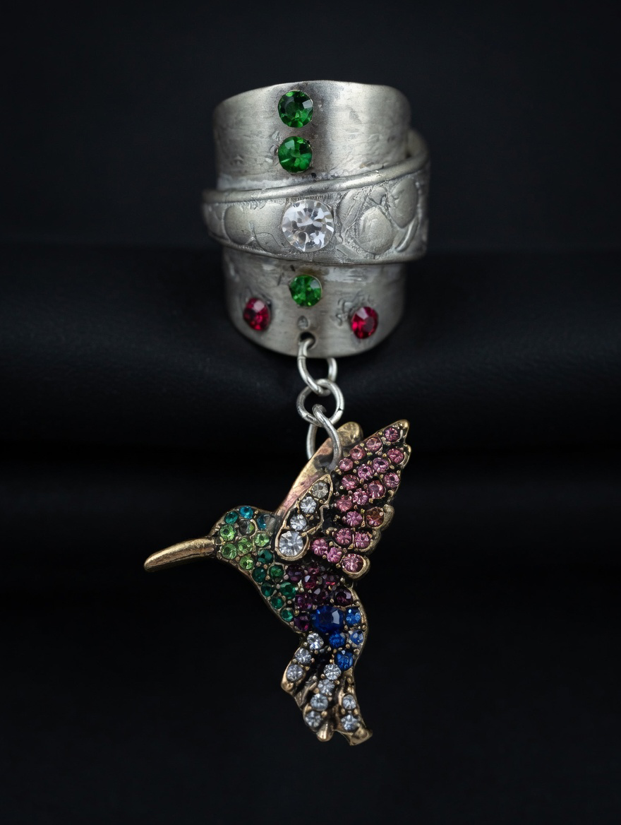 Silver-toned artisan jewelry with colorful accents and a hummingbird pendant